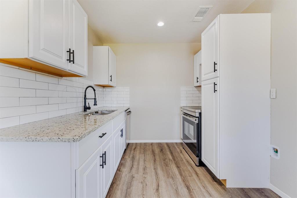 3305 Elm Grove Road Rowlett, TX 75098 - Photo 8 of 24 Kitchen with decorative backsplash, light stone countertops, light wood-style floors, white cabinets, and recessed lighting