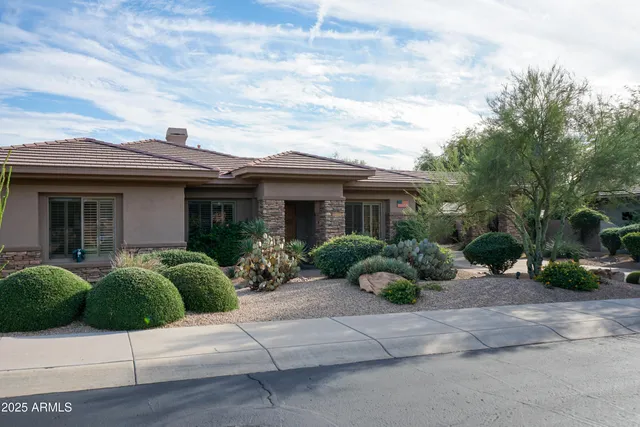 a front view of a house with a yard and potted plants