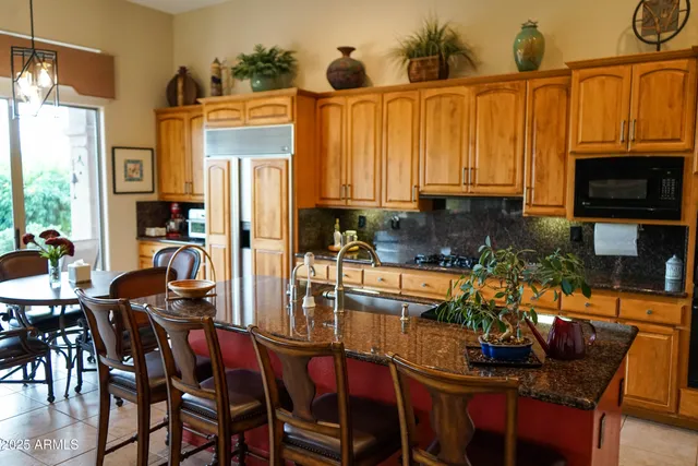 a kitchen with granite countertop a table chairs stove and granite counter tops