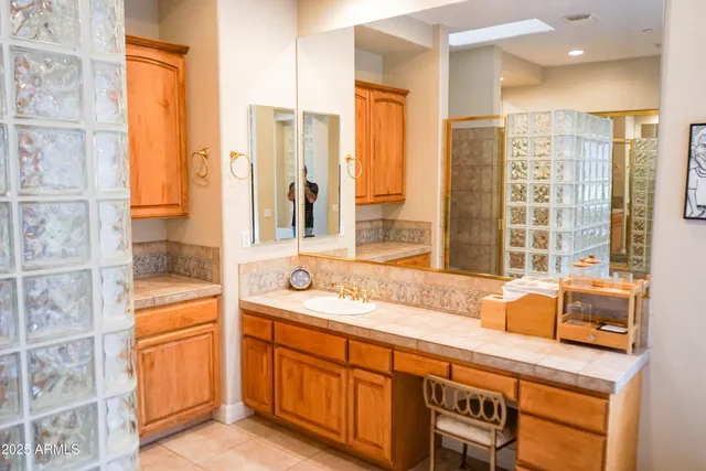a bathroom with a granite countertop sink and a shower