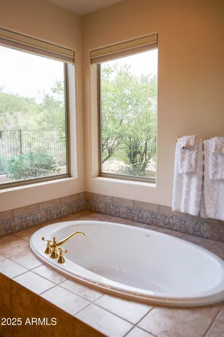 a bathroom with a granite countertop window and a bathtub
