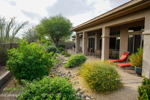 a view of a chair and table in backyard of the house