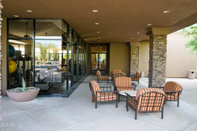 a living room with furniture potted plant and a large window