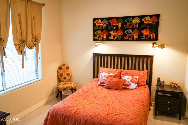 a bed sitting in a bedroom next to a window