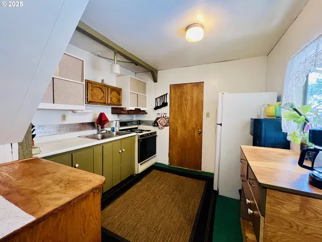 a kitchen with a sink a refrigerator and cabinets