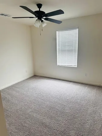 a view of a room with a ceiling fan and a window