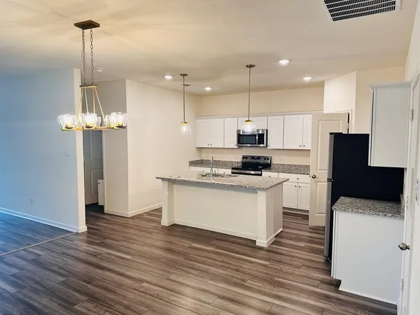 a kitchen with a refrigerator and a stove top oven