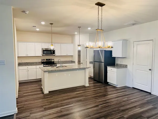a kitchen with kitchen island white cabinets and stainless steel appliances