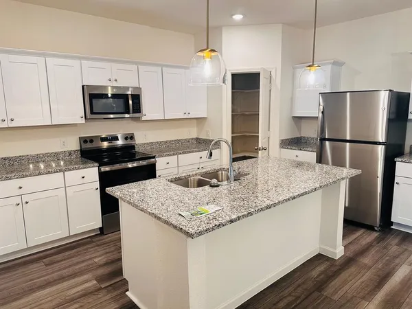 a kitchen with stainless steel appliances granite countertop a sink stove and refrigerator