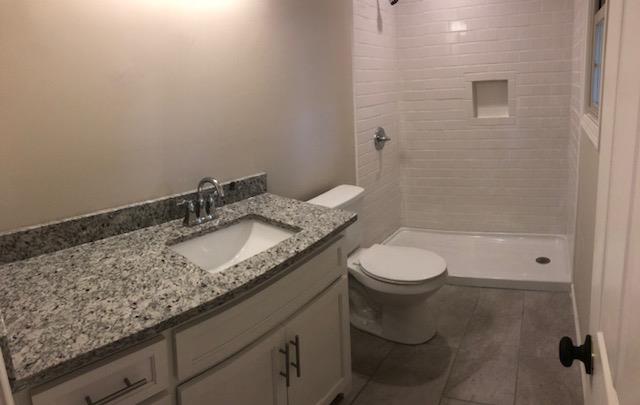 309 Butler Road Portland, TN 37148 - Photo 15 of 30 a bathroom with a granite countertop sink a toilet and shower