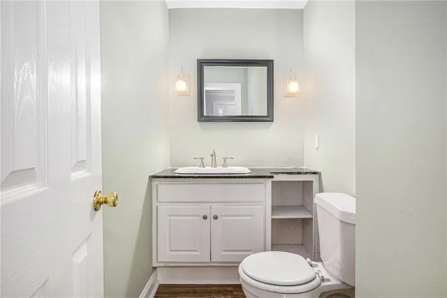 a bathroom with a granite countertop toilet sink and mirror