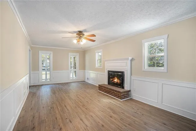 an empty room with windows and fireplace