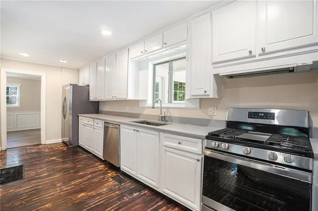 a kitchen with stainless steel appliances granite countertop a stove a sink and a refrigerator