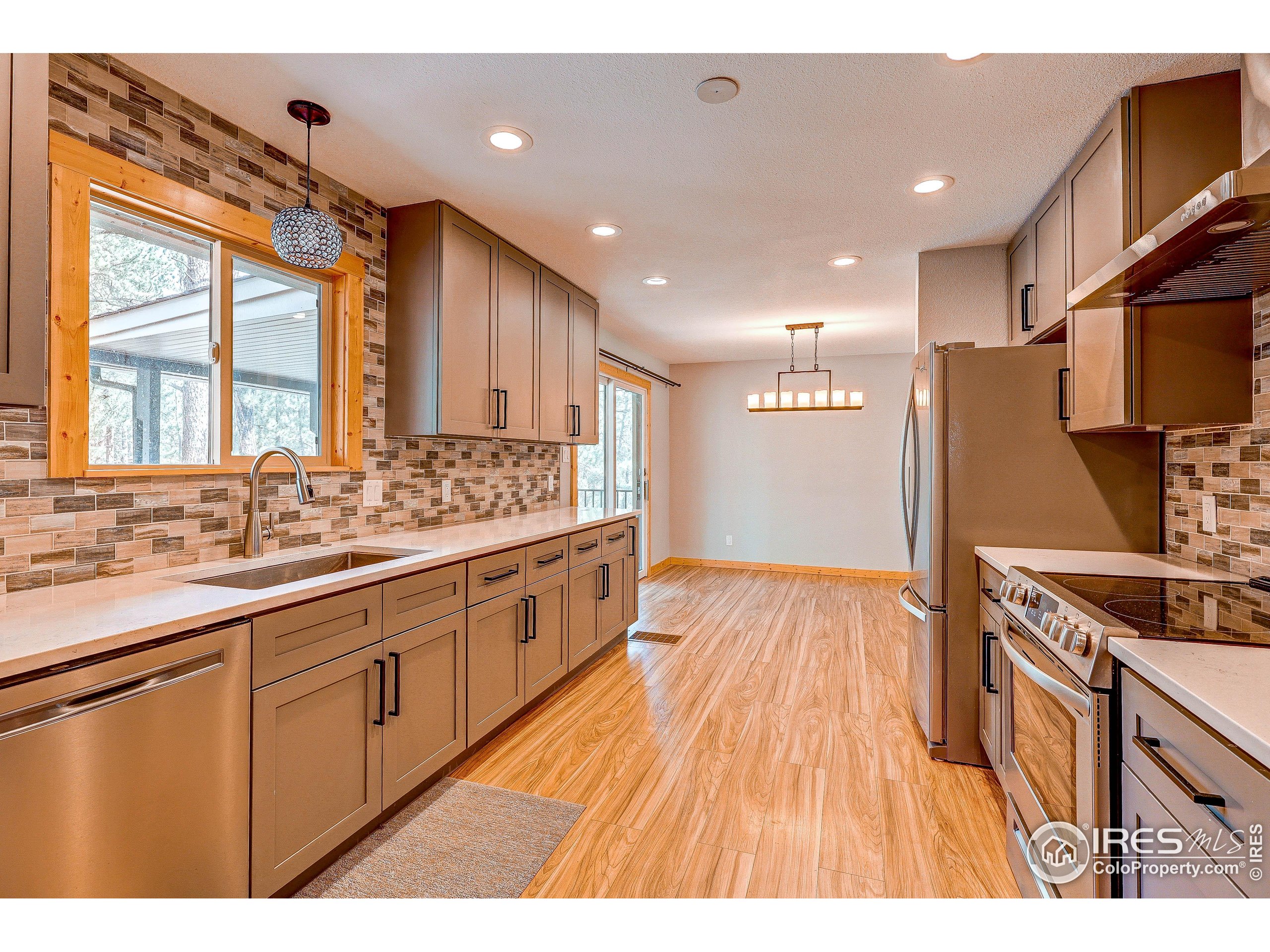 166 Cherokee Road Lyons, CO 80540 - Photo 13 of 38 a open kitchen with stainless steel appliances granite countertop a sink and wooden floor