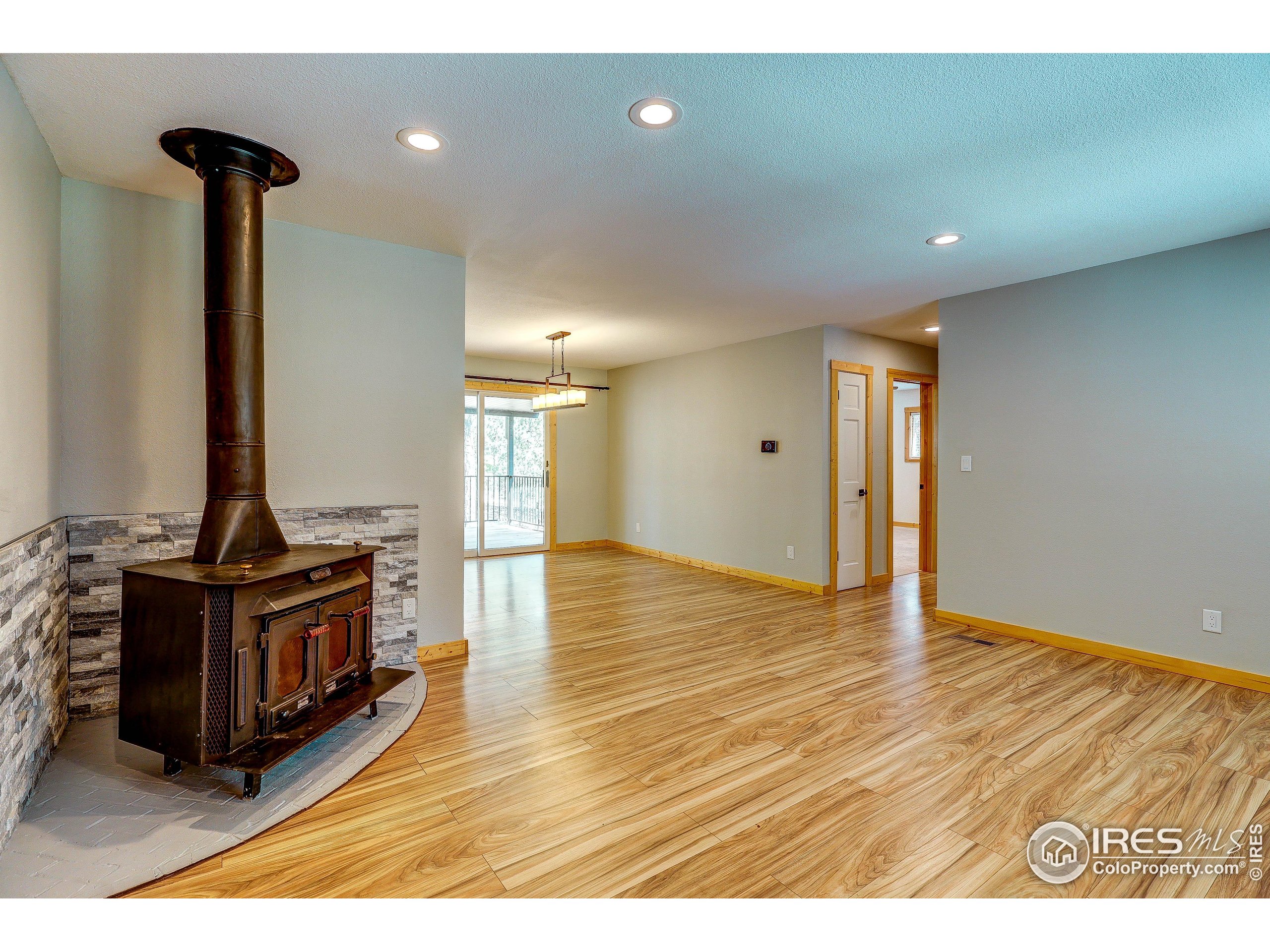 166 Cherokee Road Lyons, CO 80540 - Photo 4 of 38 a view of an empty room and kitchen with furniture wooden floor