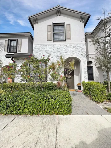 a front view of a house with a garden