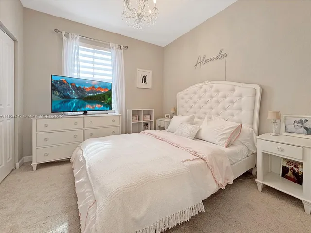 a large bed sitting in a bedroom next to a window