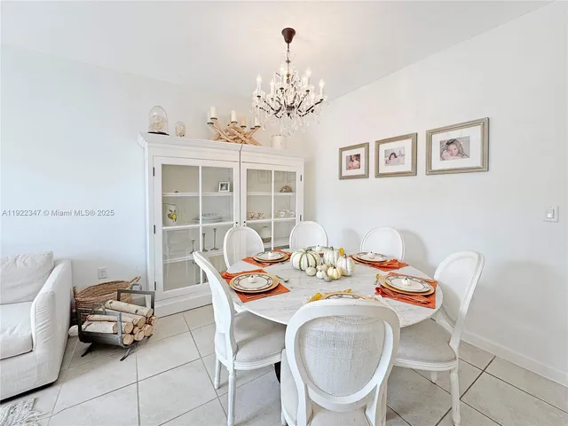 a view of a dining room with furniture a chandelier and wooden floor