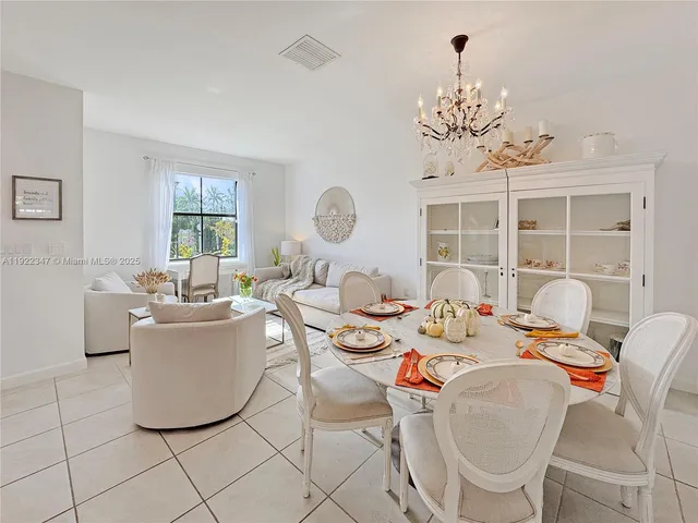 a dining room with furniture a chandelier and window