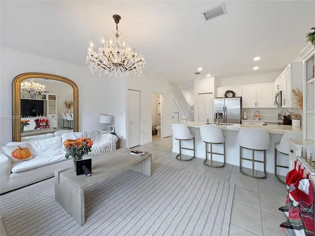 a living room with furniture and a chandelier