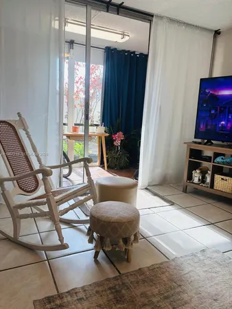 a living room with furniture and a floor to ceiling window