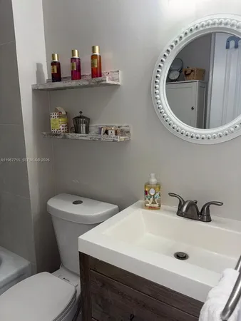 a bathroom with a sink a toilet and a mirror