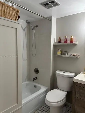 a white toilet sitting next to a bath tub and shower