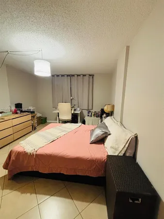 a bedroom with bed and a chandelier