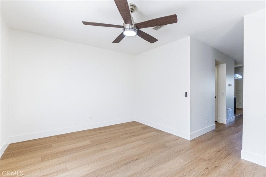 4 Wintergreen, Unit 4 Irvine, CA 92604 - Photo 15 of 39 an empty room with wooden floor and a ceiling fan