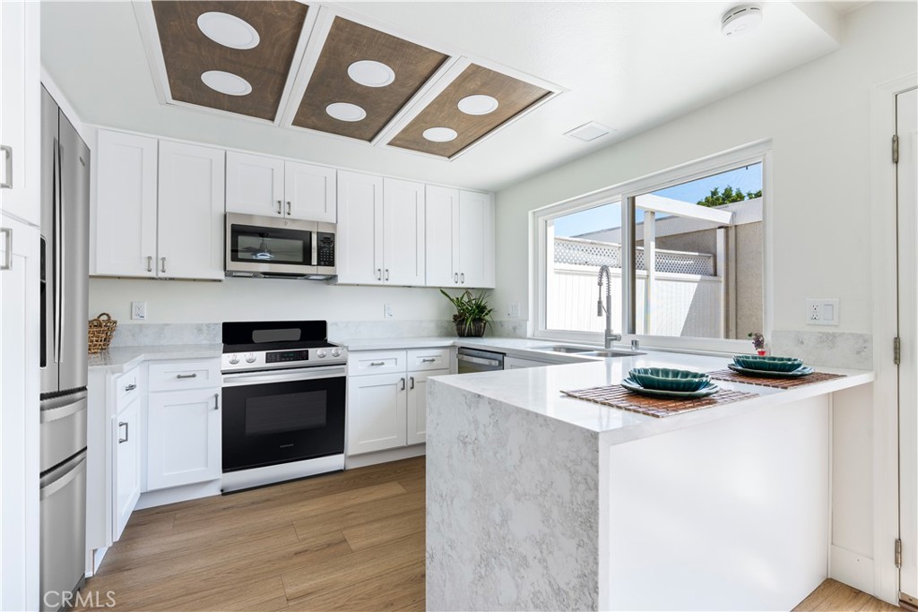 4 Wintergreen, Unit 4 Irvine, CA 92604 - Photo 8 of 39 a kitchen with stainless steel appliances a stove sink microwave and cabinets
