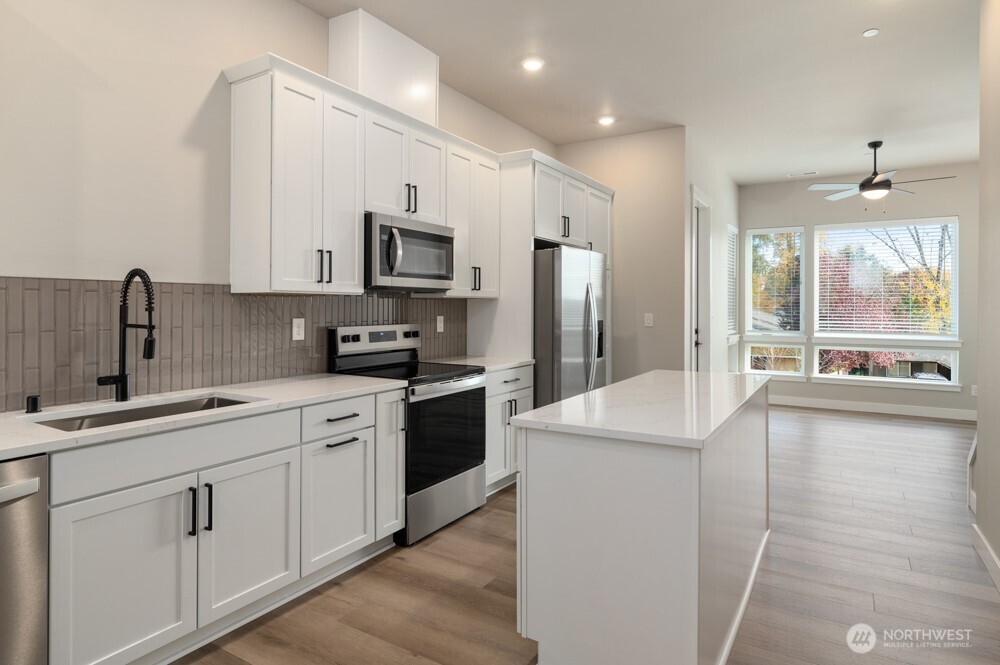 6611 South 128th Street Seattle, WA 98178 - Photo 5 of 20 a kitchen with stainless steel appliances sink stove refrigerator and cabinets