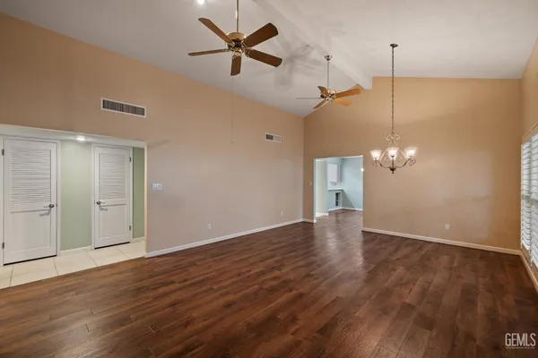 a view of an empty room with wooden floor fireplace and a window