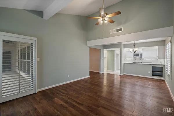 a view of a kitchen with a sink wooden cabinet and stainless steel appliances
