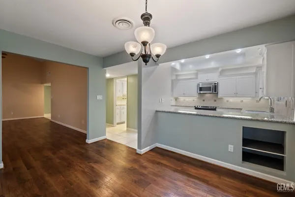 a kitchen with stainless steel appliances granite countertop white cabinets sink and stove
