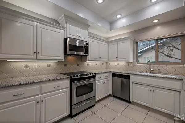 a kitchen with cabinets stainless steel appliances and a counter space
