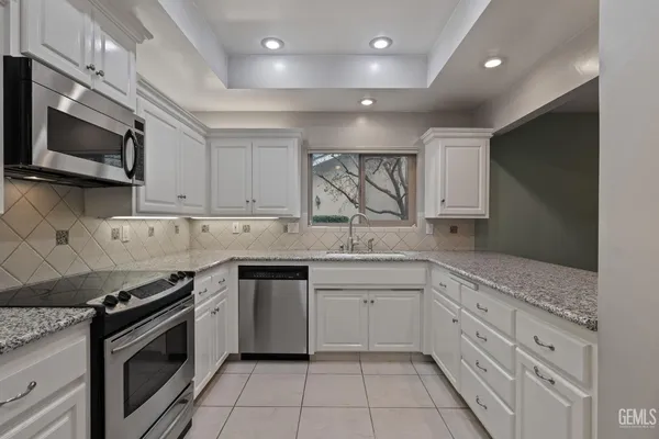 a view of a kitchen with white cabinets