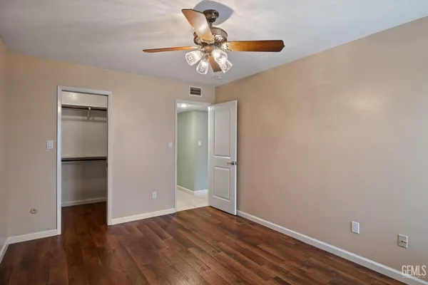 a backyard of a house with table and chairs plants and large tree