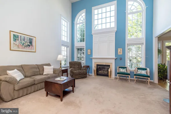 a living room with stainless steel appliances furniture a kitchen view and a living room