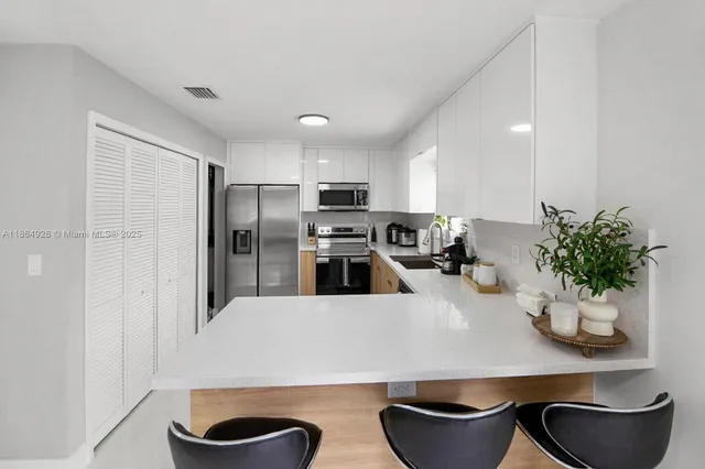 a kitchen with white cabinets and stainless steel appliances