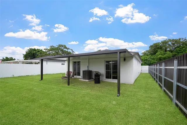 a view of a house with a yard and sitting area