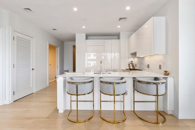 a kitchen with a sink and chairs