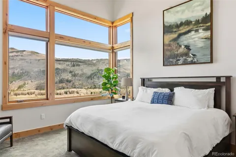 a bedroom with a large bed and a painting on the wall