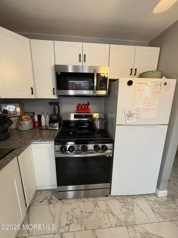 a kitchen with stainless steel appliances granite countertop a sink stove and cabinets