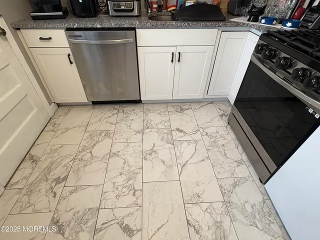 a kitchen with stainless steel appliances granite countertop a refrigerator stove a sink dishwasher and a stove