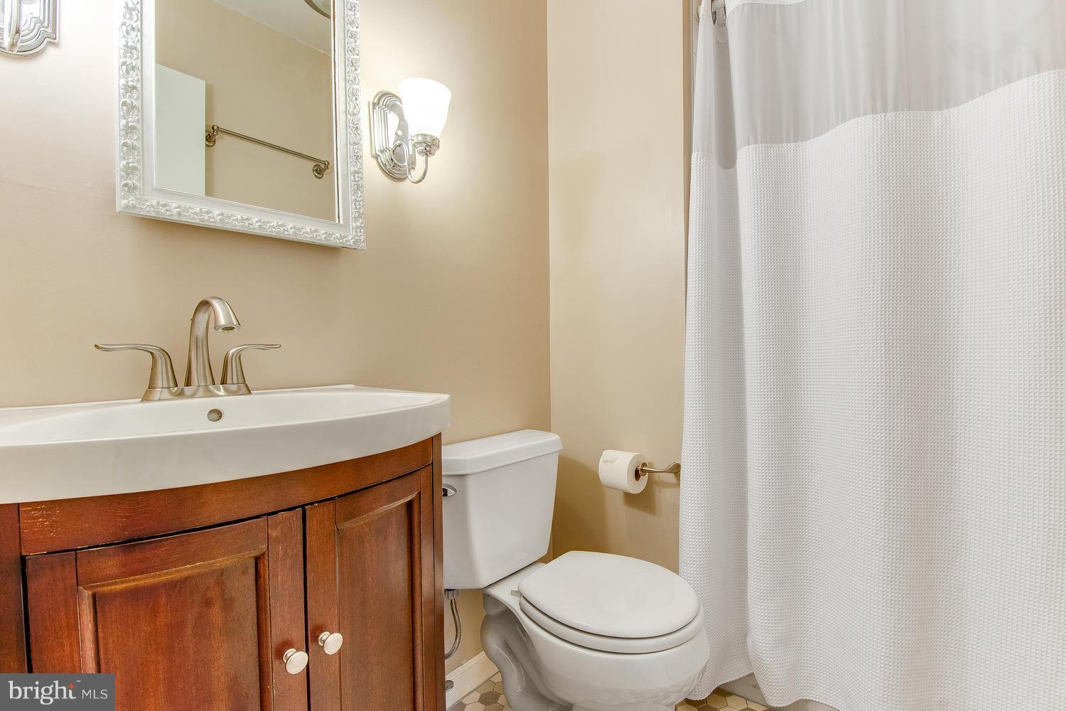 18908 Bloomfield Road Olney, MD 20832 - Photo 14 of 30 a bathroom with a toilet a sink and a mirror