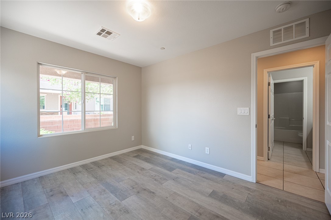 9916 Sable Point Street Las Vegas, NV 89178 - Photo 17 of 73 A well-lit bedroom with durable flooring offers a view of the peaceful neighborhood.