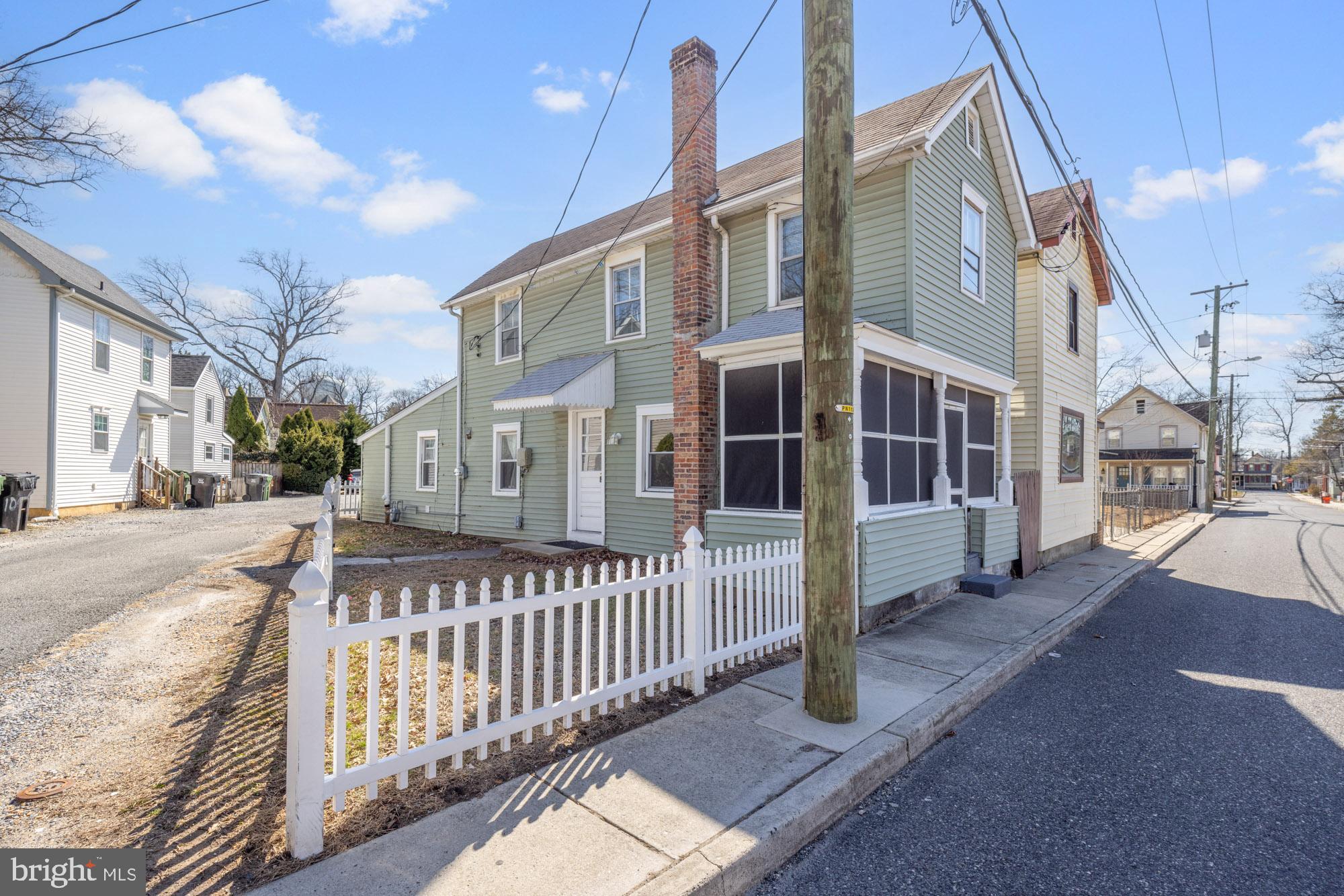 131 North Avenue Pitman, NJ 08071 - Photo 4 of 17 a view of a brick house with large windows and a small yard