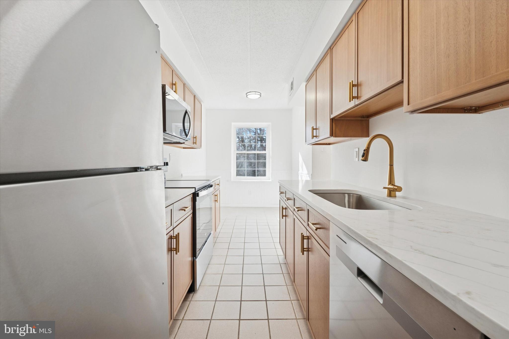 612 Washington Place, Unit 12 Chesterbrook, PA 19087 - Photo 3 of 15 a kitchen with a sink a refrigerator and cabinets