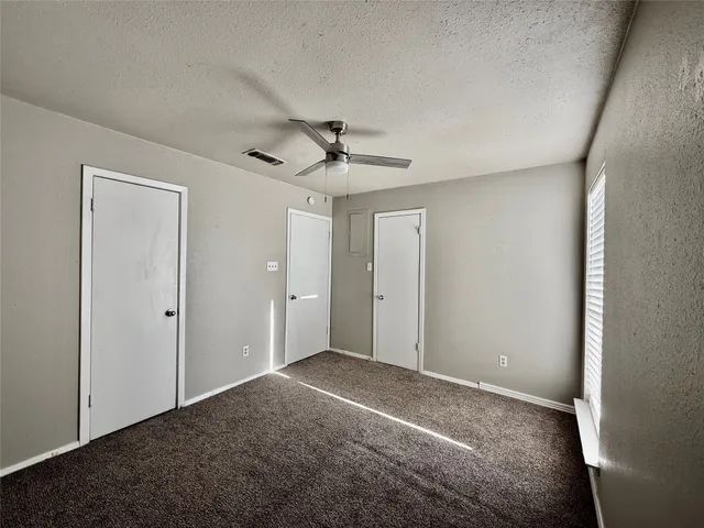 a view of a livingroom with a ceiling fan & a window