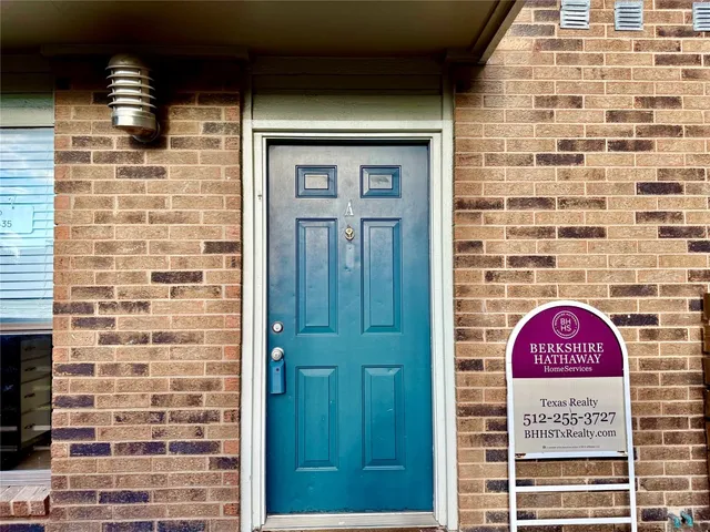 a view of a door with brick walls